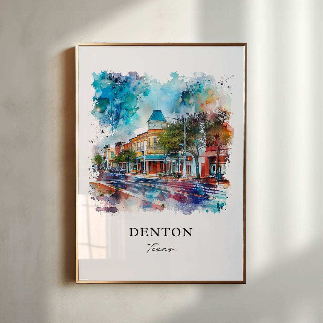 Denton Texas watercolor wall art in a gold frame featuring the historic downtown square, colorful storefronts, rain-kissed streets, and blue skies.