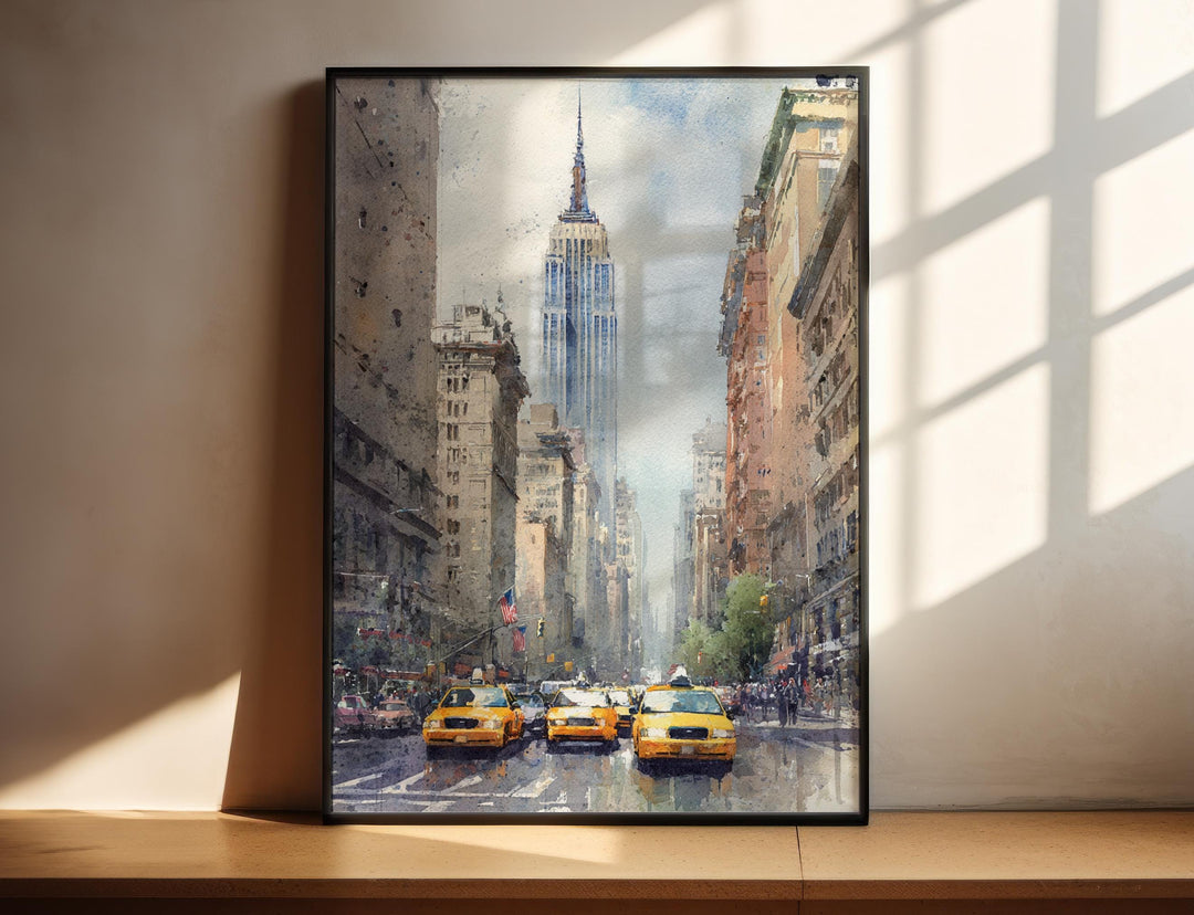 Black framed Empire State Building, New York watercolor wall art featuring iconic Manhattan streets and classic yellow taxis in a soft cityscape.