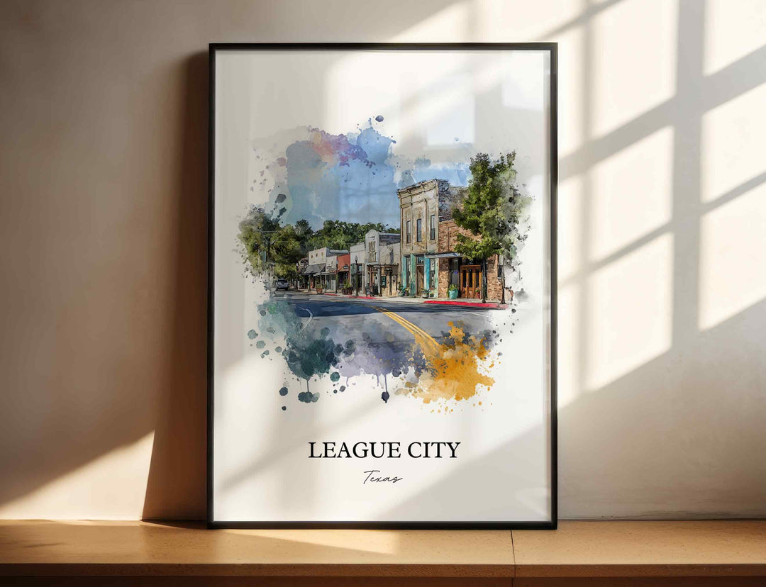 League City Texas watercolor wall art in a black frame featuring historic Main Street storefronts, leafy trees, soft blue skies, and warm watercolor accents.