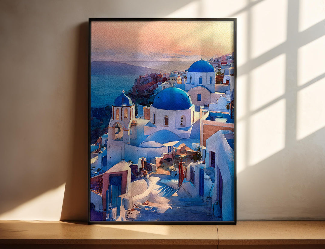 Watercolor Santorini Blue Domes wall art in a black frame featuring iconic whitewashed churches with blue domes overlooking the Aegean Sea, a stunning Greece travel print.